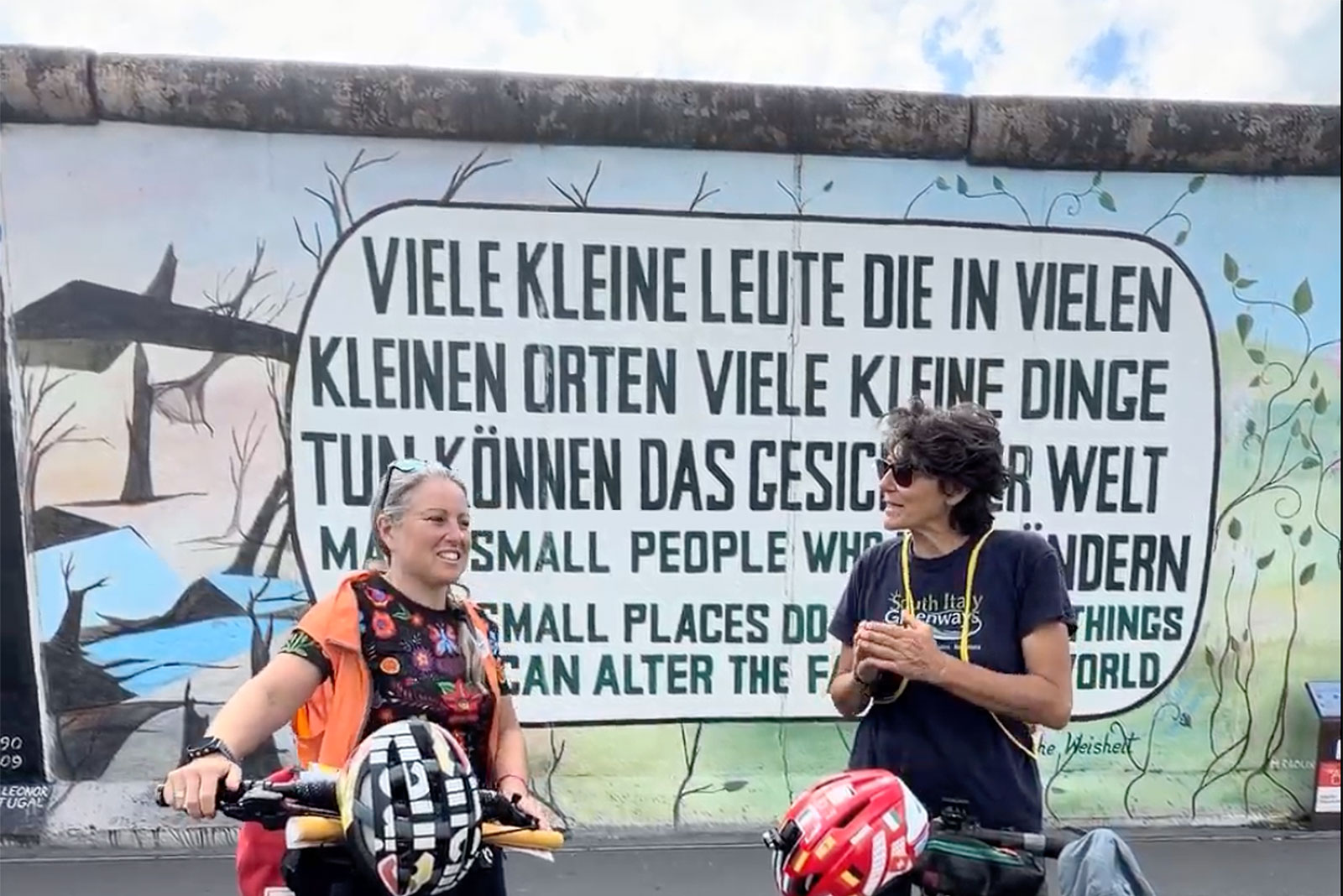 In bici davanti al Muro di Berlino